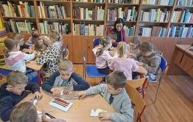 Dzieci wykonują pracę techniczną przy stolikach