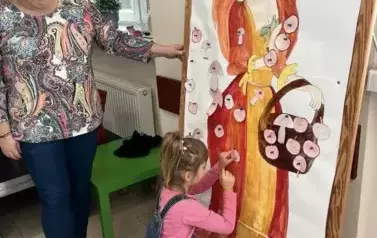 Dziewczynka przyczepiająca listki