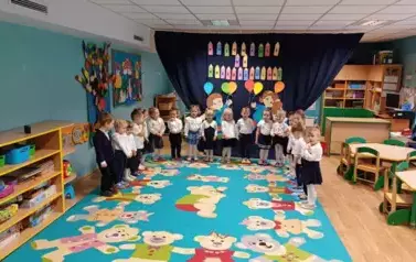 Grupa maluszk&oacute;w na tle dekoracji