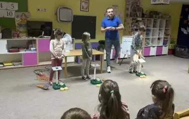 Pan prowadzący oraz dzieci eksperymentujące z panelem słonecznym