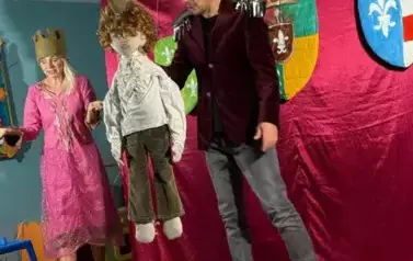 Aktorzy występujący na scenie wraz z kukiełką