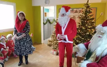 Mikołaj na tle choinki oraz pani dyrektor