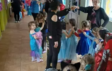 Dzieci robiące pociąg i przechodzące pod tunelem zrobionym przez panie