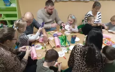 Rodzice z dziećmi wykonują kwiatka