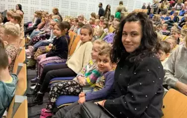 Dzieci siedzące na widowni razem z wychowawcą