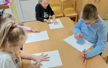 Dzieci rysują przy stoliku