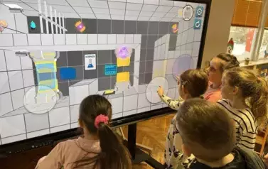 Dzieci grają w grę edukacyjną na monitorze interaktywnym
