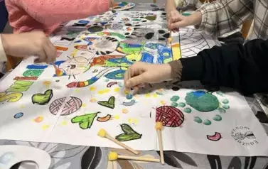Dzieci wykonują wsp&oacute;lną pracę plastyczną