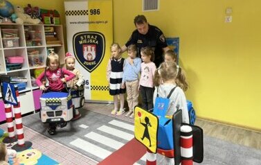 Strażnik miejski i dzieci uczące się prawidłowych zachowań na ulicy