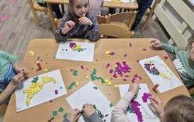 Dzieci wykonują pracę plastyczną - dinozaura