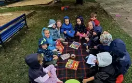 Dzieci siedzą na kocu