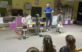 Pan prowadzący oraz dzieci eksperymentujące z panelem słonecznym