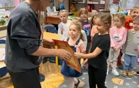 Dziewczynka wręcza podziękowanie pani biblitekarce