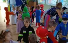 Dzieci tańczące w k&oacute;łkach oraz pan prowadzący