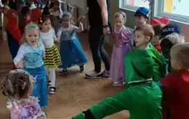 Dzieci tańczące w kole z paniami