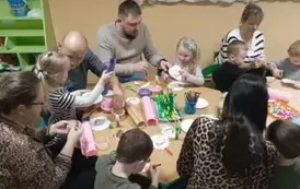 Rodzice z dziećmi wykonują kwiatka