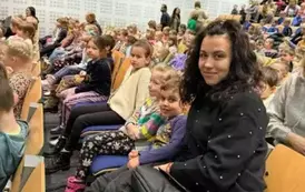 Dzieci siedzące na widowni razem z wychowawcą