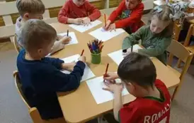 Dzieci rysują przy stoliku