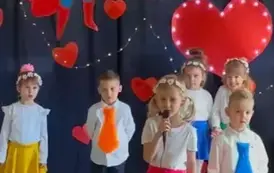 Dzieci wraz z dziewczynką m&oacute;wiąca wiersz