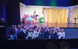 Przedszkolaki na tle sceny i aktor&oacute;w