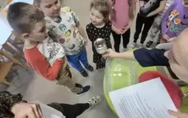 Pani pokazuje dzieciom jak pali się świeczka