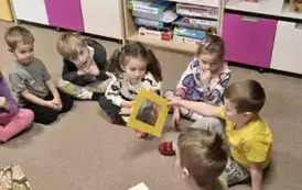 Dzieci siedzą w kole i segregują obrazki w zależności od danego żywiołu
