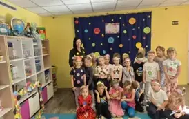 Grupa 5 wraz z panią na tle kropkowej dekoracji