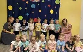Grupa maluszk&oacute;w na tle dekoracji w kropki wraz z paniami