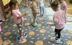 Dzieci stoją w szarfach z piłkami w tym samym kolorze