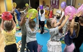 Dzieci trzymają balony nad głowami w parach