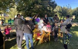 Stoisko z balonami oraz grupa rodzic&oacute;w