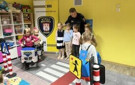 Strażnik miejski i dzieci uczące się prawidłowych zachowań na ulicy