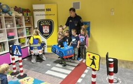 Strażnik miejski i dzieci uczące się prawidłowych zachowań na ulicy