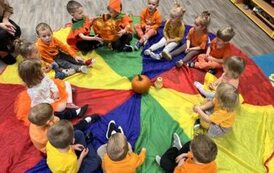 Dzieci siedzą na chuście animacyjnej 
