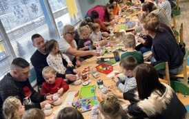 Rodzice z dziećmi wykonują bałwanka ze skarpety