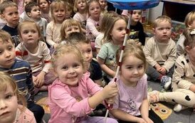 Grupa dzieci i dziewczynka trzymająca talerz na patyku