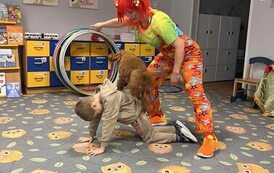 Piesek przeskakujący przez hula hop po plecach chłopca