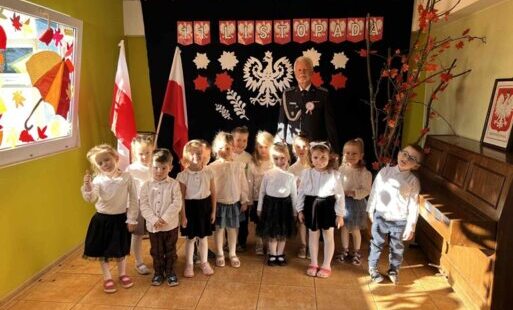 Grupa dzieci z żołnierzem na tle dekoracji