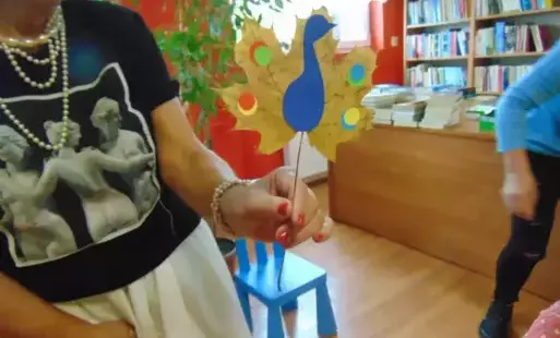 Pani trzymająca pawia z papieru