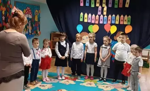 Dzieci na tle dekoracji oraz pani dyrektor